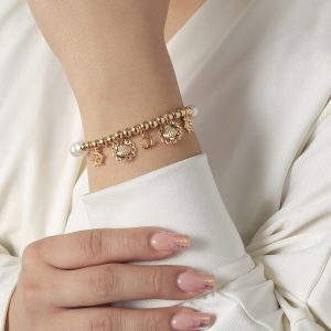 Pulsera dama con dijes dorados y perlas